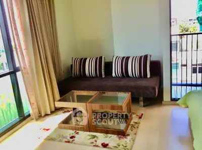 Cozy living room with modern furniture and large windows overlooking balcony