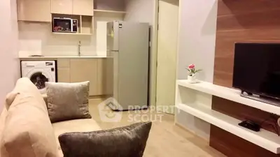 Modern open-plan living room with kitchen, featuring a washing machine and sleek appliances.