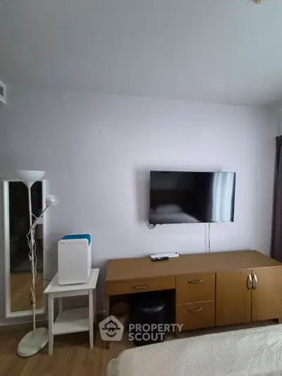 Modern bedroom with wall-mounted TV and stylish wooden furniture
