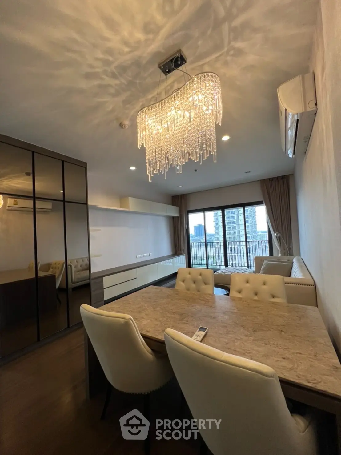 Luxurious living room with elegant chandelier and city view balcony