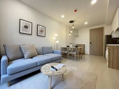 Modern living room with cozy sofa and stylish dining area in open layout apartment.