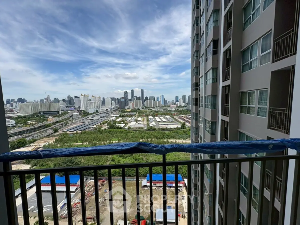 Stunning cityscape view from high-rise balcony overlooking urban skyline and lush greenery.