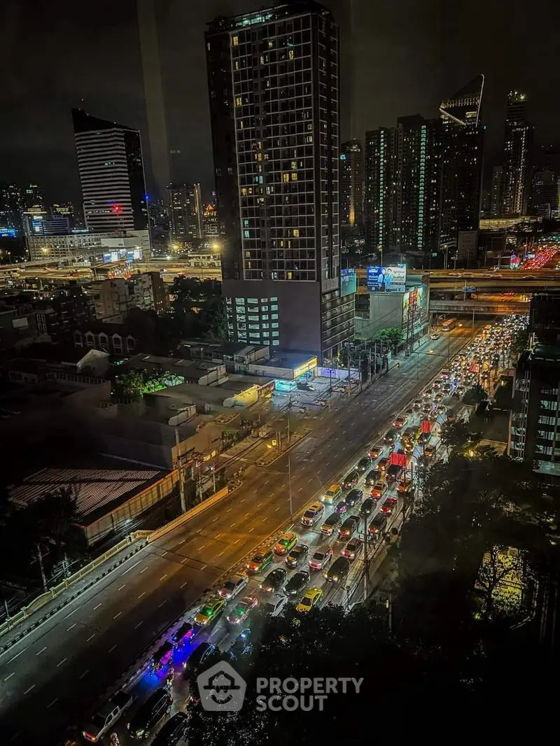 Stunning cityscape view from high-rise building at night with vibrant city lights and bustling traffic.