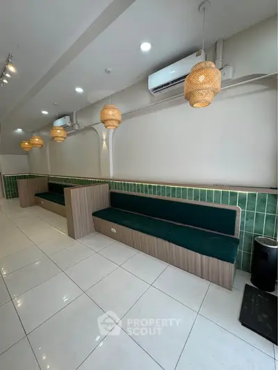 Modern interior with stylish seating and green tile accents in a well-lit space.
