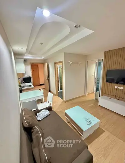Modern living room with stylish ceiling design and cozy furniture in a contemporary apartment.