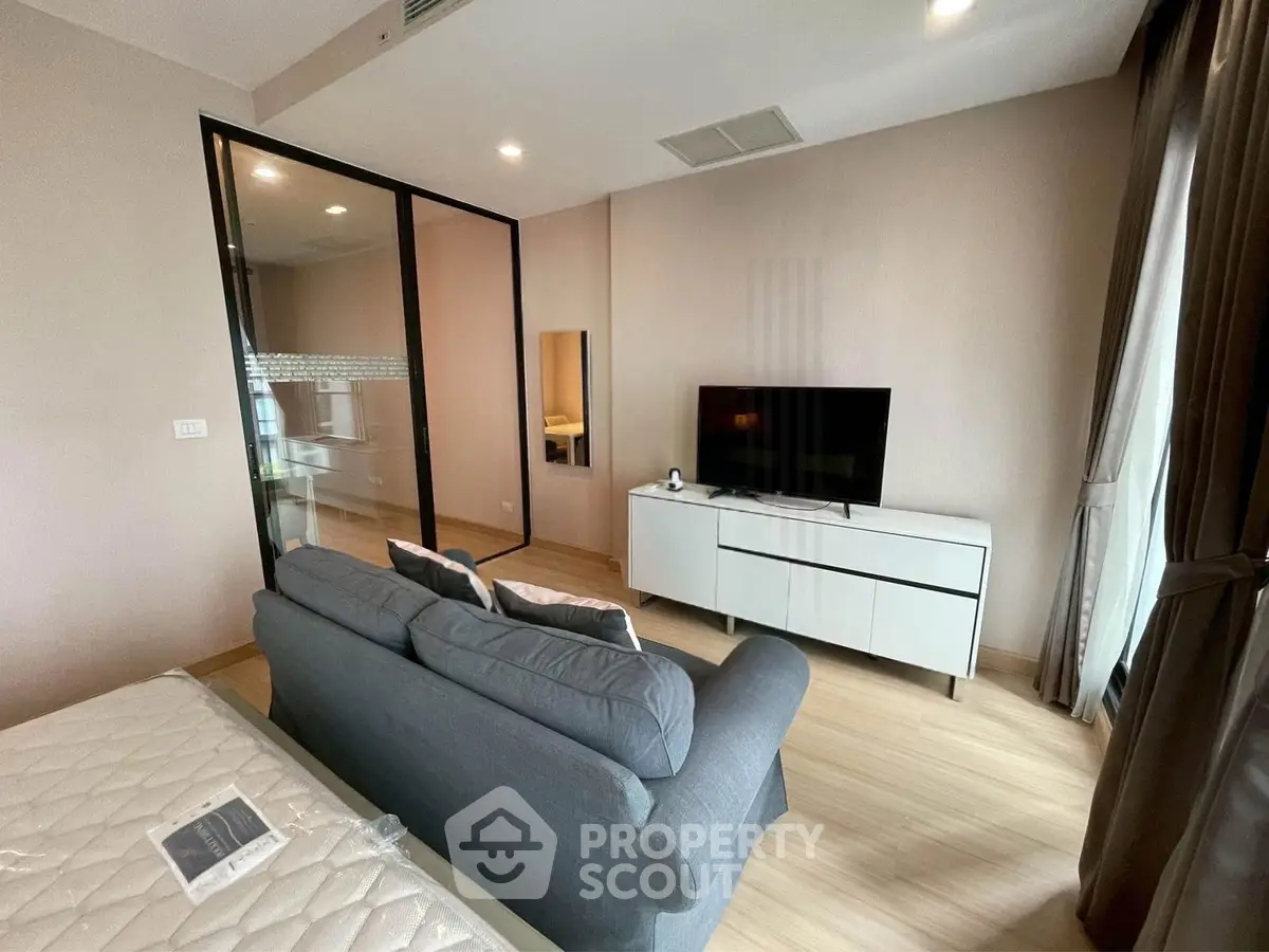 Modern living room with sleek glass partition and cozy sofa in a stylish apartment.