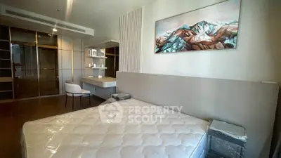 Modern bedroom with stylish decor and spacious closet in luxury apartment.