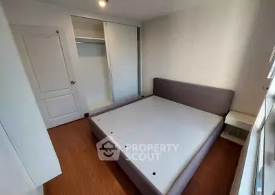 Spacious bedroom with modern bed frame and built-in closet, perfect for comfortable living.