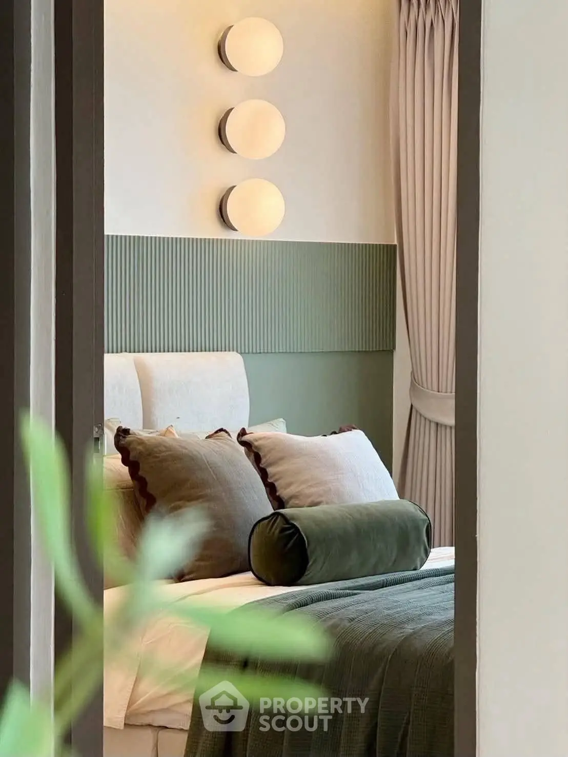 Elegant bedroom with modern decor and soft lighting, featuring plush pillows and stylish wall accents.