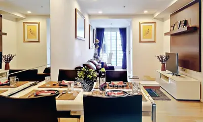 Modern living room with dining area, stylish decor, and natural light from large windows.