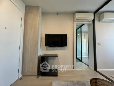 Modern living room with wall-mounted TV and air conditioning in stylish apartment.