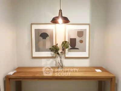 Stylish modern interior with wooden console table, abstract art, and pendant light.
