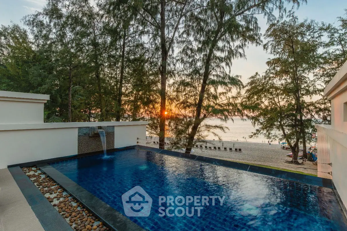 Luxurious beachfront infinity pool with stunning sunset views and serene surroundings.