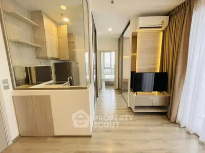 Modern apartment interior with open kitchen and living area, featuring sleek design and natural light.