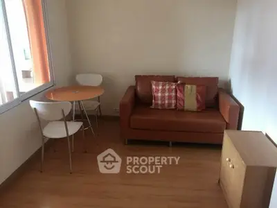 Cozy living room with brown sofa and small dining table, perfect for compact spaces.