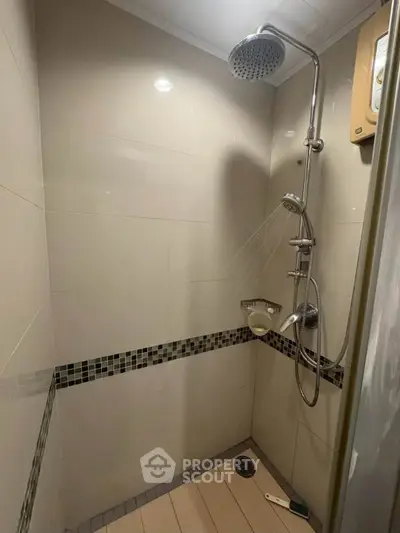 Modern bathroom shower with sleek tile design and rainfall showerhead.