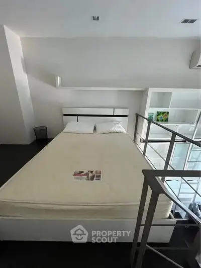 Modern bedroom with minimalist design and loft-style railing, perfect for urban living.