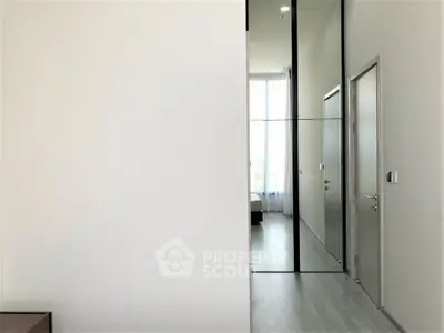 Modern minimalist bedroom with large mirror and natural light