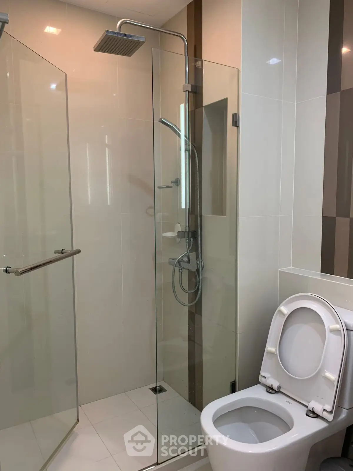 Modern bathroom with glass shower and toilet, sleek design