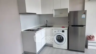Modern compact kitchen with washing machine and stainless steel fridge