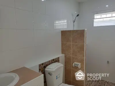 Spacious bathroom with modern fixtures, neutral tile flooring, and ample natural light from a frosted window.