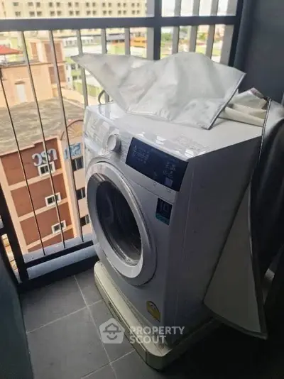 Modern washing machine on a balcony with city view, perfect for urban living convenience.