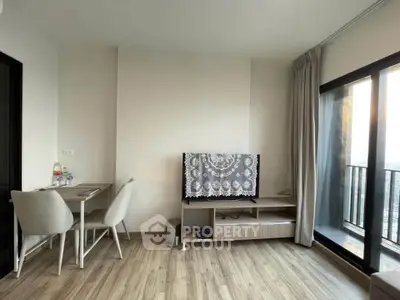 Modern living room with balcony view, stylish furniture, and natural light.