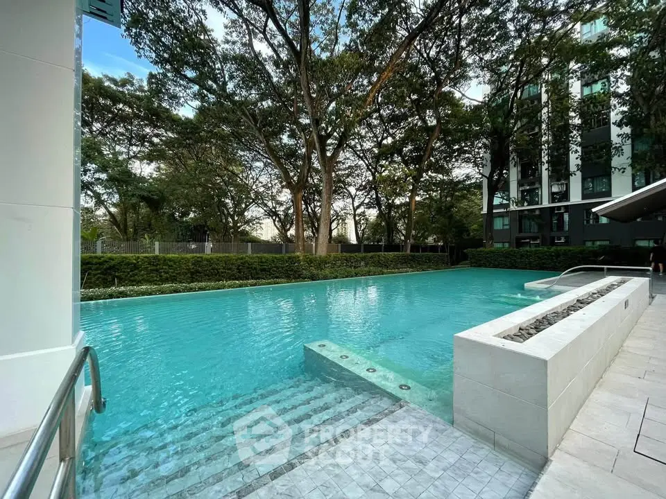 Luxurious residential pool with serene surroundings and lush greenery