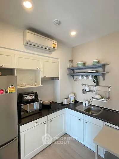Charming kitchen with modern appliances and sleek cabinetry in cozy apartment