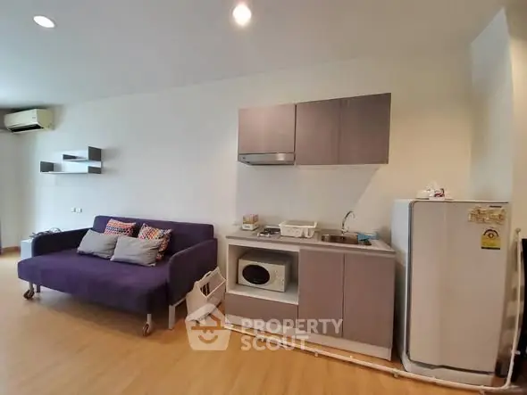 Modern studio apartment with compact kitchen and cozy living area