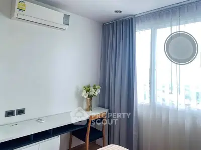 Modern bedroom with air conditioning and elegant curtains, featuring a sleek desk and chair setup.