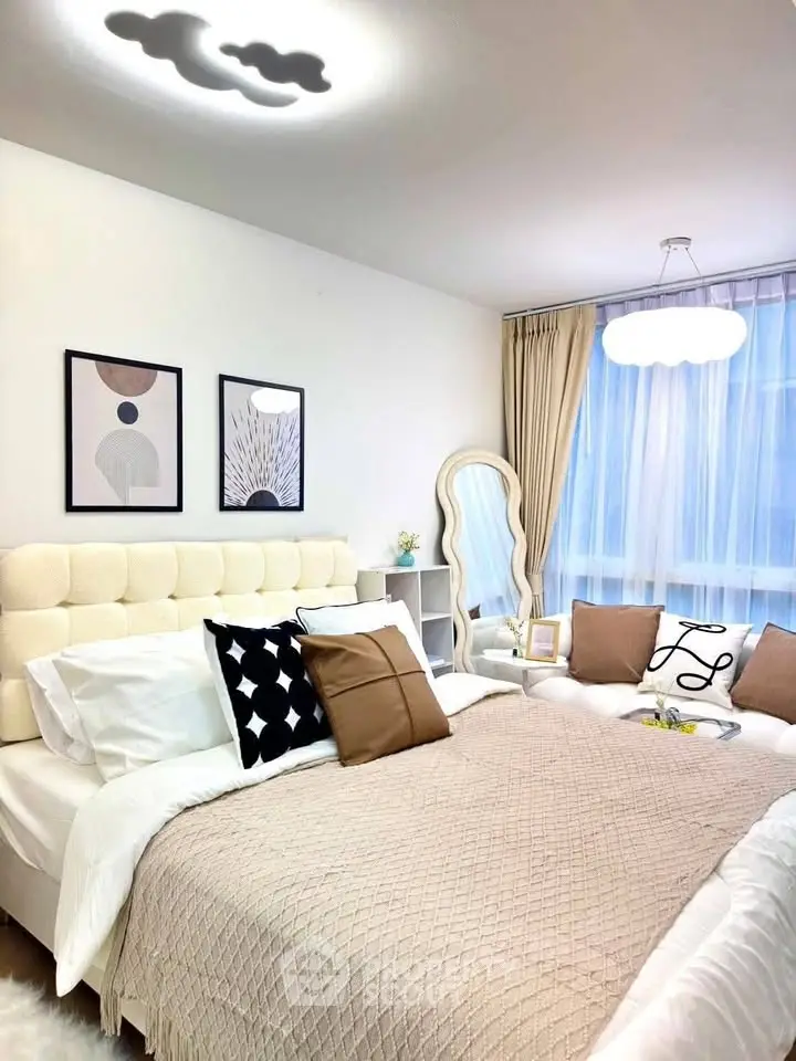 Elegant bedroom with modern decor, plush bedding, and natural light from large windows.