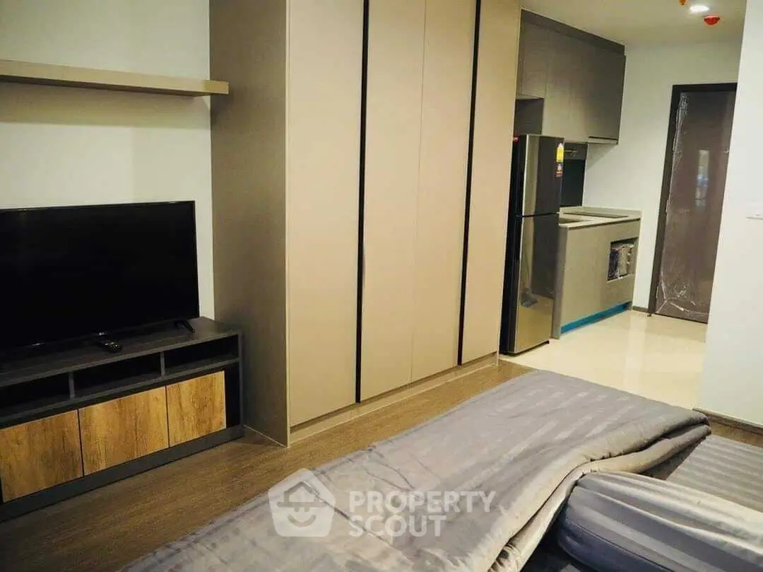 Modern studio apartment with sleek kitchen and cozy living area, perfect for urban living.