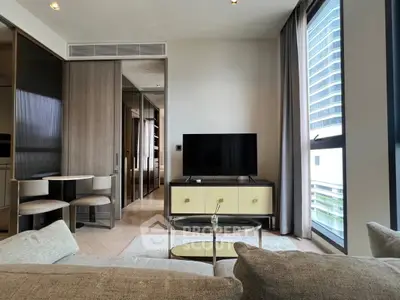Modern living room with stylish furniture and large window offering city views.