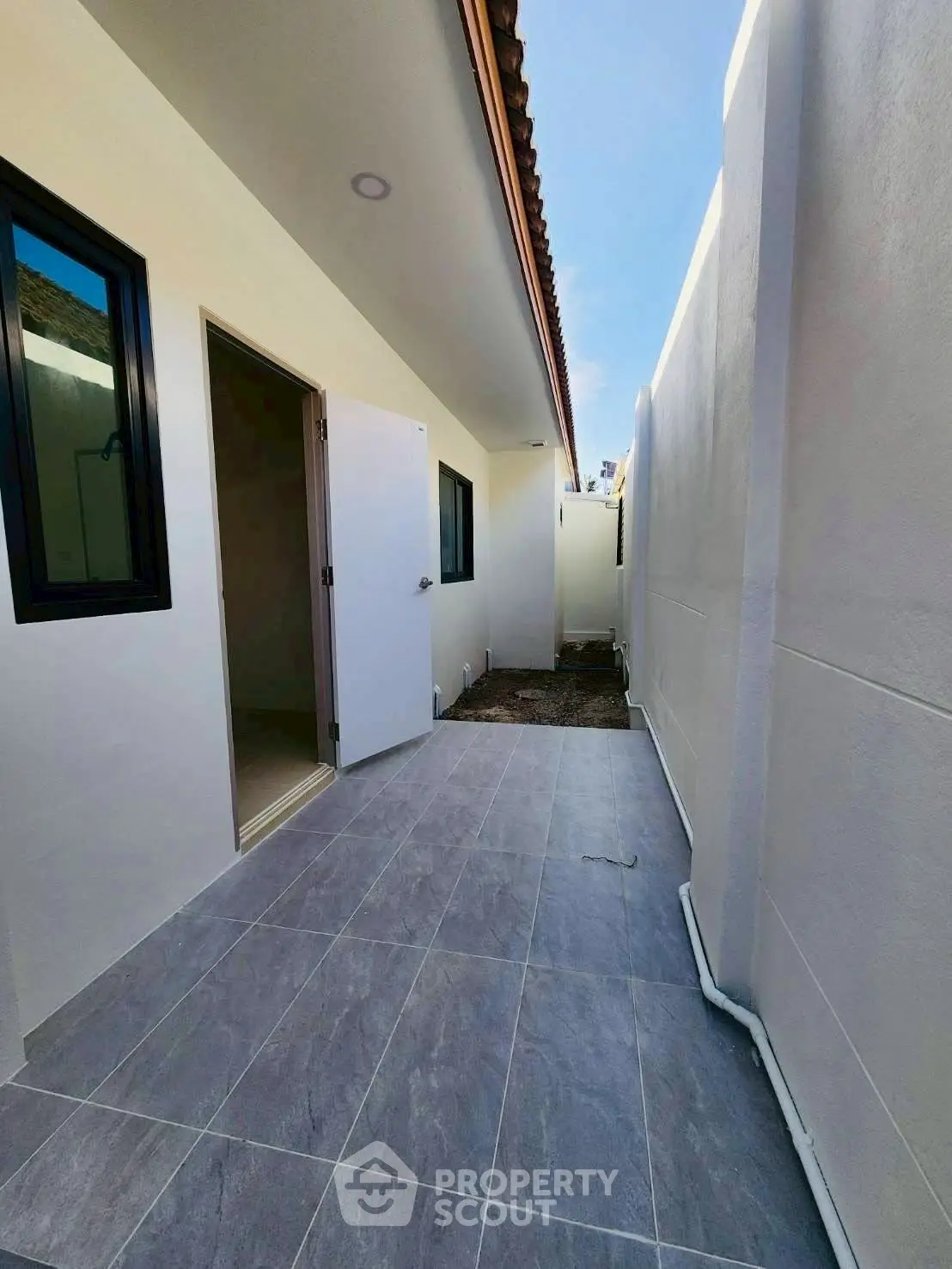 Modern exterior corridor with tiled flooring and white walls