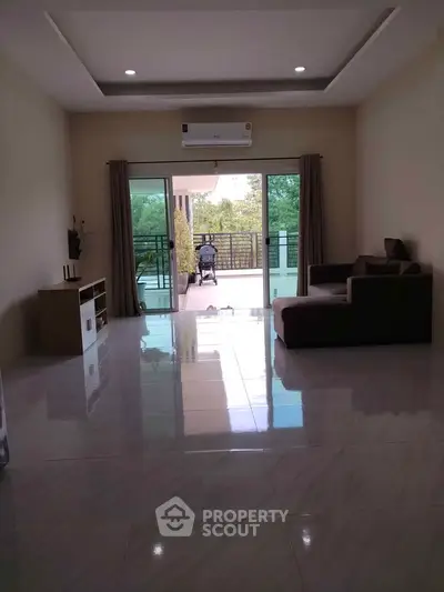 Spacious living room with large balcony and modern furniture