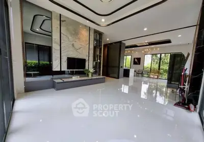 Spacious modern living room with sleek design and large windows offering lush garden views.