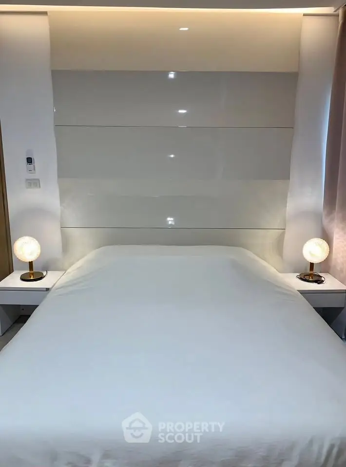 Modern bedroom with sleek design and ambient lighting, featuring a comfortable bed and stylish bedside lamps.