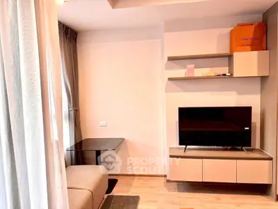 Modern living room with sleek TV stand and cozy seating area, perfect for relaxation.