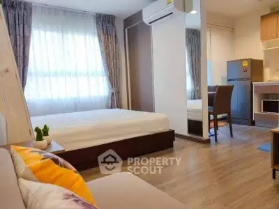 Modern studio apartment with cozy bedroom and compact kitchen area