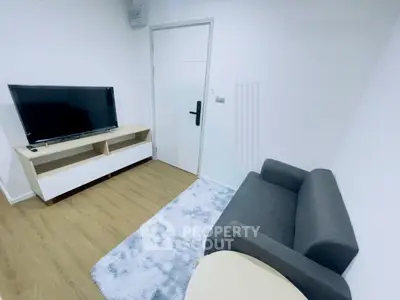 Modern living room with sleek furniture and flat-screen TV, perfect for cozy relaxation.