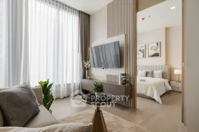 Modern living room with elegant decor and view into a cozy bedroom