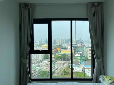 Stunning cityscape view from a modern bedroom window in a high-rise apartment.