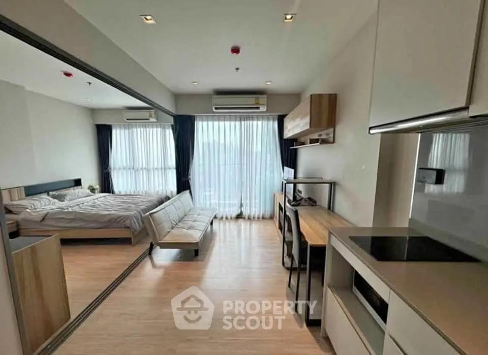 Modern studio apartment with open layout, featuring a cozy bedroom and sleek kitchen area.