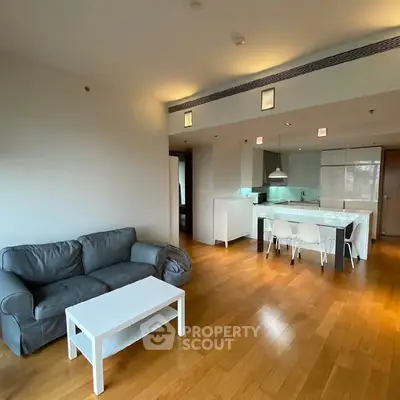 Modern open-plan living room with sleek kitchen and hardwood floors