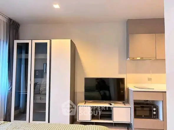 Modern studio apartment with sleek kitchen and cozy living area, perfect for urban living.