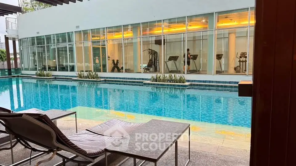 Luxurious poolside view with modern gym facilities in the background