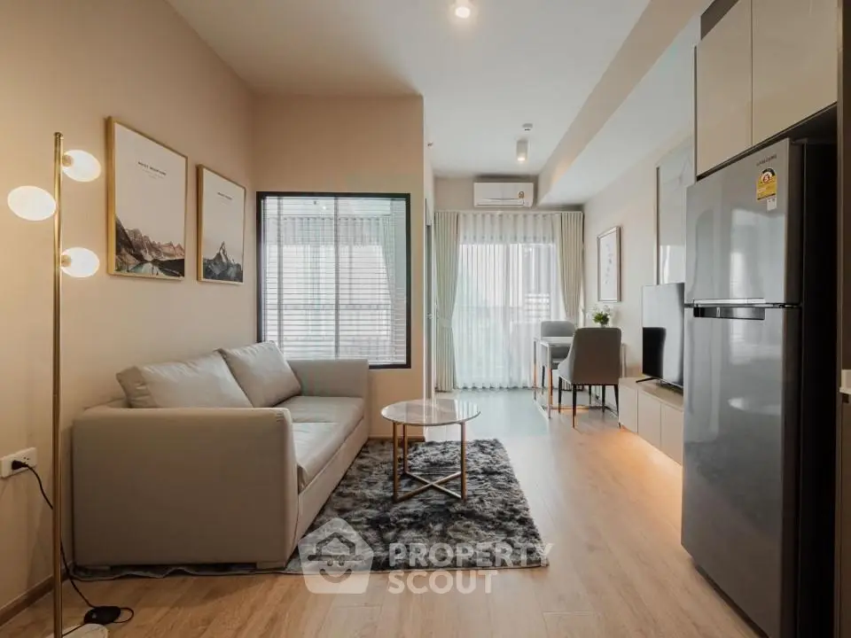 Modern living room with cozy sofa, stylish decor, and open layout leading to dining area.