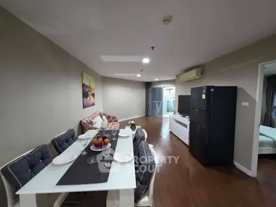 Spacious living room with dining area and modern furnishings in a stylish apartment.