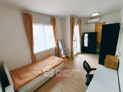 Cozy bedroom with single bed, desk, and wardrobe in bright apartment